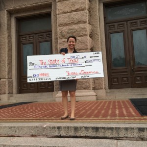 U. Houston’s Youth Empowerment Alliance, holds a check symbolizing the contributions of undocumented youth to the state of Texas